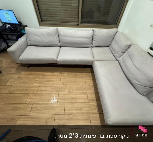 ספה אפורה על רצפת עץ עם סימני ניקוי